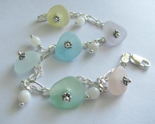 Rainbow Sea Glass Bracelet - Six pieces of sea glass adorn this 7 1/2' sterling silver bracelet. The bracelet is accented with mother of pearl polished shell beads. The colors of sea glass in this bracelet are yellow, lavender, aqua blue, white, seafoam green & pink.