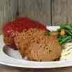 meatloaf with ketchip atop - recipes can vary however it is all the same a great loaf of meat that can be made into other things after the original meal if there is any left