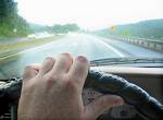 Hands on the wheel, Eyes ahead - man driving a car on a rainy day