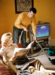Man cleaning - A man cleaning the house while women relaxes