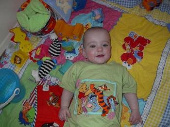 baby on floor - baby lying on a floor playing with her toys and smiling.