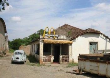 Here you can see an old McDonalds - In this picture you can see an old McDonalds,where you find only people from country.This McDonalds from this picture hasn&#039;t any customers and maybe in few years would not be in the same place.If this McDonalds would be in the city here were many customers that eat hamburgers and others stuff from McDonalds.