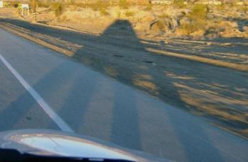 Shadow Car - Photo of a shadow cast by my car with the sun behind us. The angle of the sun caused the wheel shadows to lengthen while the body of the car compressed giving the shadow the look of a UFO. Shadow Car - Photo of a shadow cast by my car with the sun behind us. The angle of the sun caused the wheel shadows to lengthen while the body of the car compressed giving the shadow the look of a UFO.