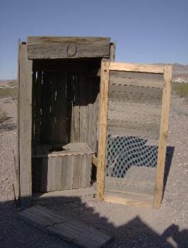 Old time outhouse - A wooden plank with a hole for a seat over a hole in the ground. Dirty, cold in winter, hot and smelly in summer. And pray you don&#039;t get a splinter.