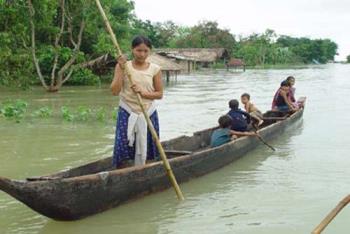 girl in a boat in flood - One girl taking children in a boat in a flooded are