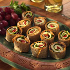 Veggie Wrap-Ups - To assemble wraps, spread each tortilla with 3 tablespoons hummus. Sprinkle 1 tablespoon olives over hummus. Place 1 lettuce leaf on bottom half of tortilla. Top with 2 slices cheese. Place 1 tablespoon roasted red pepper strips and 1/4 cup cucumber strips onto cheese. Roll up. 