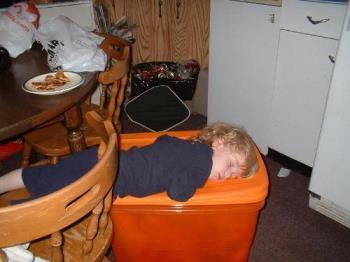 fast asleep - half under the table on a bin sleeping right through all the decorating.