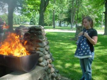 Flag Day - This is one of the photos that was taken at the Flag Day ceremony. The girl is a Senior Girl Scout from Troop #250/Troop #001. Here the scout gives the field of blue a final hug before presenting it to the fire for retirement.