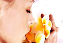 a girl smelling flowers - an ad for body scrub vichy