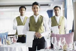 Waitress And Waiters - Waitress and waiters posing before camera before starting work at an upscale restaurant.