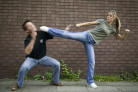 Girl kicking man - Girl is kicking a man away, her karate is undeniable