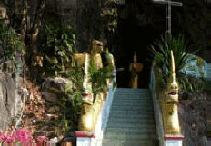 cave temple. - Lord Buddha sits inside the cave temple. It faces the Mae Kok river in Chiangrai, north Thailand.