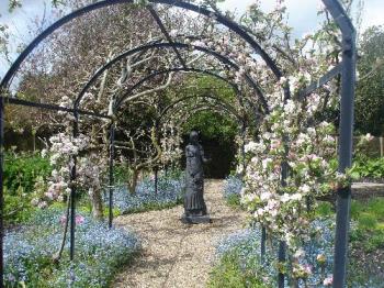 Michelham Priory - Kitchen Garden - Taken through the Apple Blossom Walkway, to the statue in the Kitchen Garden. This garden is divided into four equal parts by a pebbled, crossed pathway. Michelham Priory - Kitchen Garden - Taken through the Apple Blossom Walkway, to the statue in the Kitchen Garden. This garden is divided into four equal parts by a pebbled, crossed pathway.