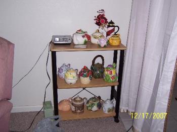 More teapots on shelves.  - One book case with teapots