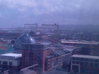View Towards Harland and Wolffe's Shipyard - Where Titanic was Built..the 2 Gantry cranes of the yard are part of the Belfast Skyline. There's currently a 200m Ferris Wheel ("The Belfast Wheel") in the Grounds of Belfast City Hall,you can see the logo in the Titanic Memorial Picture-the Memorial is actually within the framework of the wheel at present,and the View over the Shipyard is from the top of the wheel!