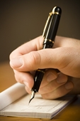 writing - photo of detailed view of man holding fountain pen and endorsing check