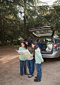 lost - photo of Girls (8-9) observing map with mother in forest