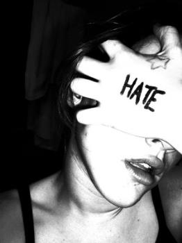 hate - girl covering her face with hate written on her hand