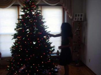 Christmas tree and girl - Picture of a Christmas tree being decorated by a young girl, this is the un-altered mystery photo. Christmas tree and girl - Picture of a Christmas tree being decorated by a young girl, this is the un-altered mystery photo.