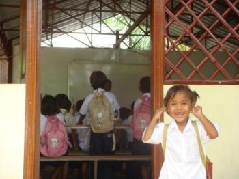 First Day of School - A snapshot of a little girl on her first day in school. Perhaps she&#039;s shy on entering the classroom.