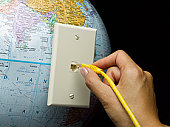plugging into the internet - photo of hand plugging in ethernet cable to globe plugging into the internet - photo of hand plugging in ethernet cable to globe