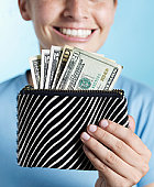 money - photo of Woman holding purse full of dollars