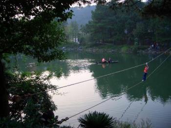 Here is one photo I took - Here is one of the photos that I took years ago for you to enjoy. The background you see in the photo is a scenic spot in our local place. You see a man walking on a rope from one side of the rope to the other over a big pond. He was just walking in the middle when I took the shot and I love this photo very much. 
