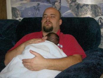 Hubby sleeping with youngest - Hubby is pretending to sleep here, while holding our youngest when he was about a month old.