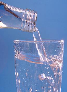 pouring a glass of water from a bottle - Here is someone pouring a glass of mineral water into a glass.