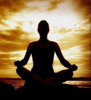meditation - a silhouette of a lady meditating. The light source behind her (sunlight) seems like a halo and there is a golden glow to her entire body. Seems like her aura has been activated!