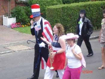 Leaders of The Parade - I believe this might be the Mayor of a local village and his wife or daughter, plus probably his granddaughter with the trumpet. They led the Stars and Stripes Parade up to the field where the Village Day fun will take place. I think he&#039;s probably portraying "Uncle Sam". Anyway, it was quite a colourful parade.