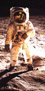 Appollo astronaut. -  An apollo astronaut, Buzz Aldren. The sunlight is reflecting off the foil onthe lunar lander in front of him, bathing him in a reddish-yellow light from the front, giving the apearence of a second light source. also reflected in his visor is the lander and another astronaut.