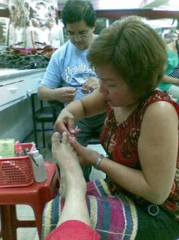 having pedicure - manicurist cleaning toes
