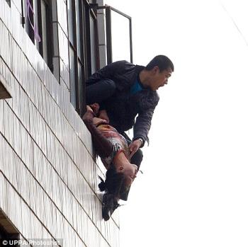 Man hangs girlfriend out the window in lovers&#039; qua - Kunming, China December, 2008. Finally specialist hostage negotiators were able to persuade the man to give himself up. 

