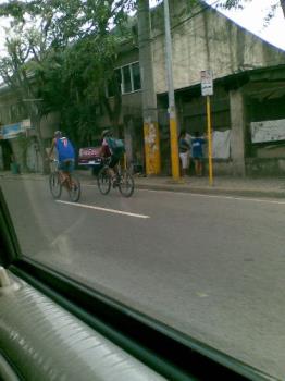 bicycle riders - bicycle riders -- one wearing a protective head gear while the other only wears a cap