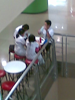 school uniform - medical students hanging out in a small cafe by the mall aisle