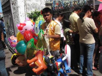 balloons - balloons and other toys sold by a vendor in a crowded church