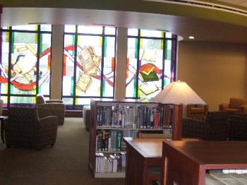 Stained glass windows at the library. - These windows are at the west end of our library and there are tables, and comfy chairs and a lowered ceiling. Nice place to read.