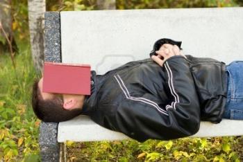 A Man Sleeping on a Park Bench with a book over hi - Here is a man at a park who seems to have fallen asleep while reading a book. We can also consider the possibility that he brought the book on purpose to cover his face while he sleeps. Then again, why not a newspaper?

