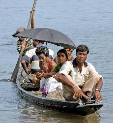flood in assam - people ferrythrough a boat during fllods in assam