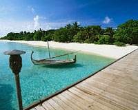 Maldives Beaches - a Maldivian island for tourists. dhoni/vessel near the faalan/bridge