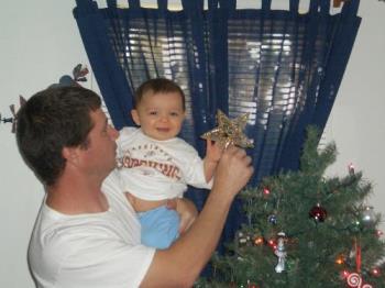Graysen and Daddy putting star on tree - Graysen  1st Christmas star