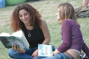 Reading - two girls reading togehter on campus park & discuss abaout what they just read