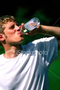 Man drinking water - Man drinking a bottle of water outside on a hot sunny daty!