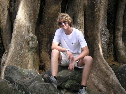 Me Posing at a Temple in Ankor Wat - This is the temple where Lara Croft was filmed at. It is set outside Siam Riep in a beautiful location, a temple built centuries ago and nature has taken over! The plants and trees literally grow through/around/over/under the temple. The trunks are massive and this picture shows me sitting on one of them. If any of you have managed to visit Cambodia I would LOVE to talk about it with you.. my experiance was simply breath-taking!