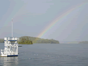 River with a rainbow - Riverside.With a rainbow.A flag in the middle.Look the beauty of the rainbow.It is a beautiful view.