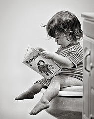 Bathroom Reading - A cute kid reading in the bathroom.