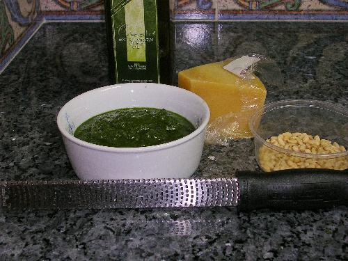 Pesto Ingredients and Microplane for Cheese - The bowl contains the finished pesto made with fresh Genoa basil, freshly grated Italian cheese (I used Grana Padana this time), pine nuts and extra virgin olive oil.    The microplane in front of the bowl of pesto is my favorite tool for grating cheese as well as many other hard foods.