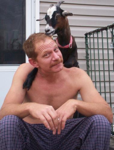 My Husband and Goat - Dont they both look so sweet, My Goat just chilling out with my hubby, we sit on the porch and talk and my goat often likes to join us. She will sit or rest her legs on us a while, My Goats Name is Abby she is not even a year old, she is a great pet.