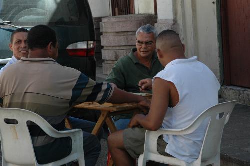 Sunday Afternoon Domino - As a tradition of the Dominican Culture, people gather around to play Domino on Saturdays or Sundays on the middle of the street with beer or rum.